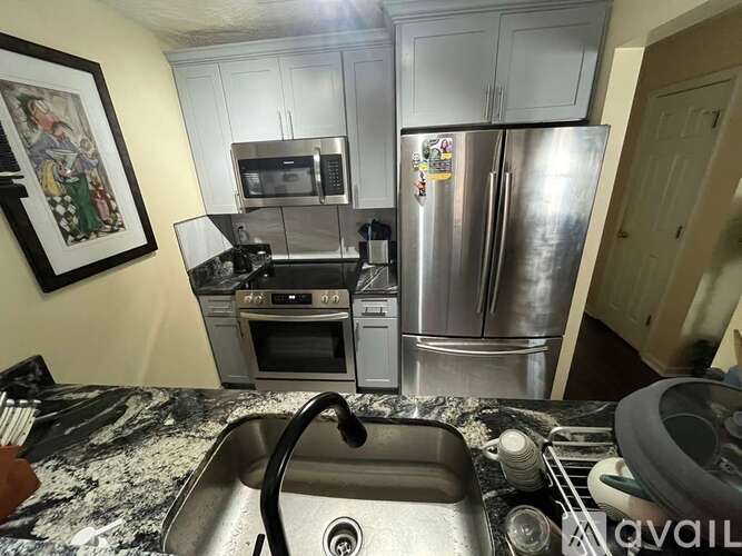 A kitchen with a stainless steel refrigerator and oven.