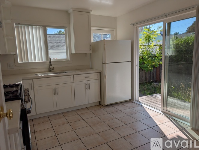 A kitchen with white appliances and cabinets is on the market.