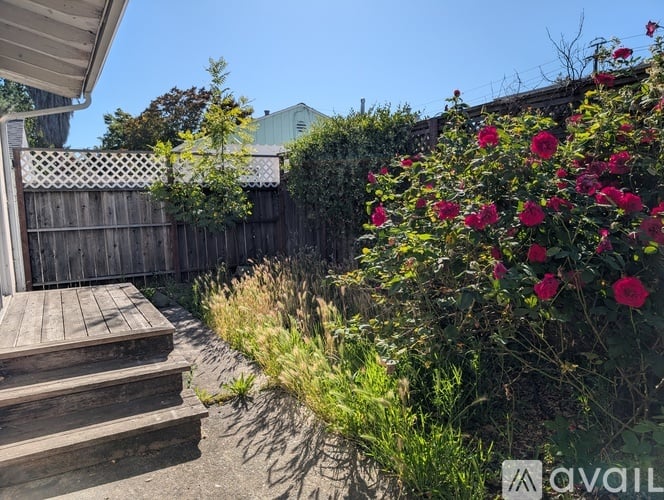 A backyard with a wooden deck and a fence.