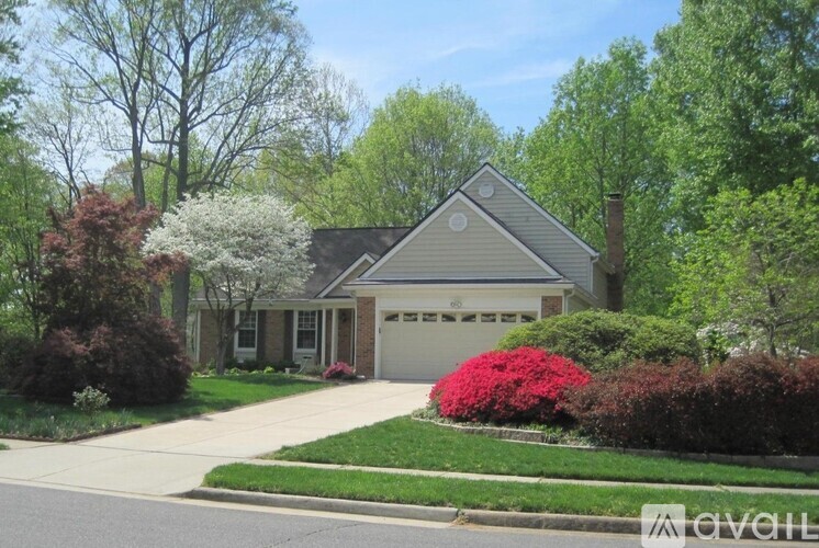 A house with a garage and a driveway in front of it.