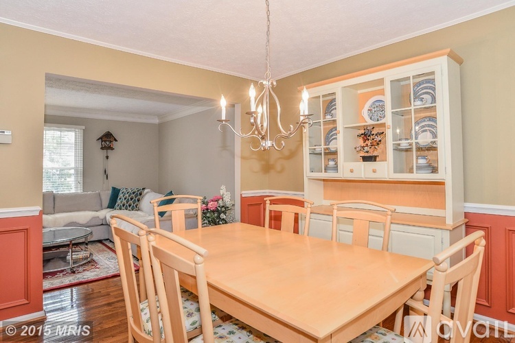 A dining room with a wooden table and chairs.