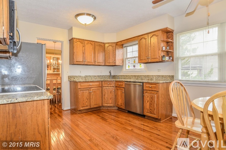 A kitchen with wooden cabinets and a granite countertop.