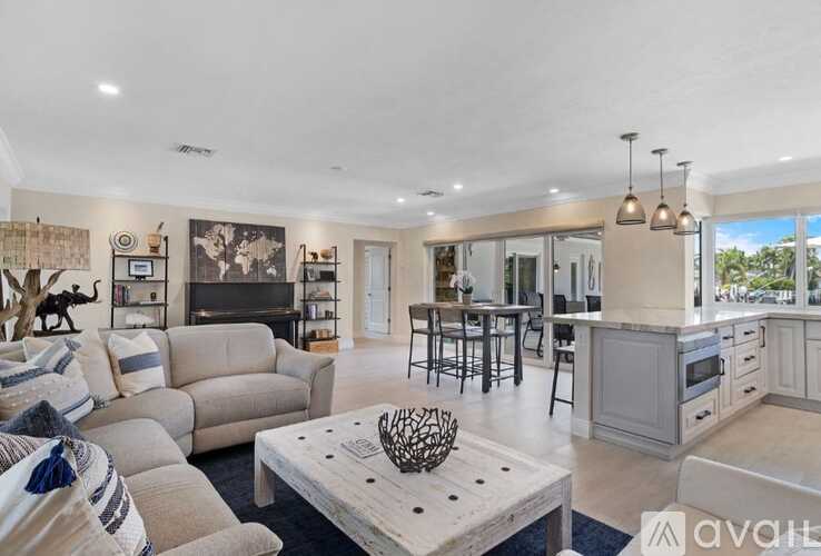 A spacious living room with a fireplace and a dining area in the background.