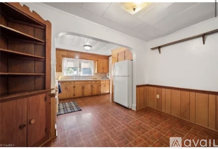 A kitchen with wooden cabinets and a tiled floor.