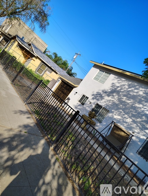 A white house with a black fence in front of it.