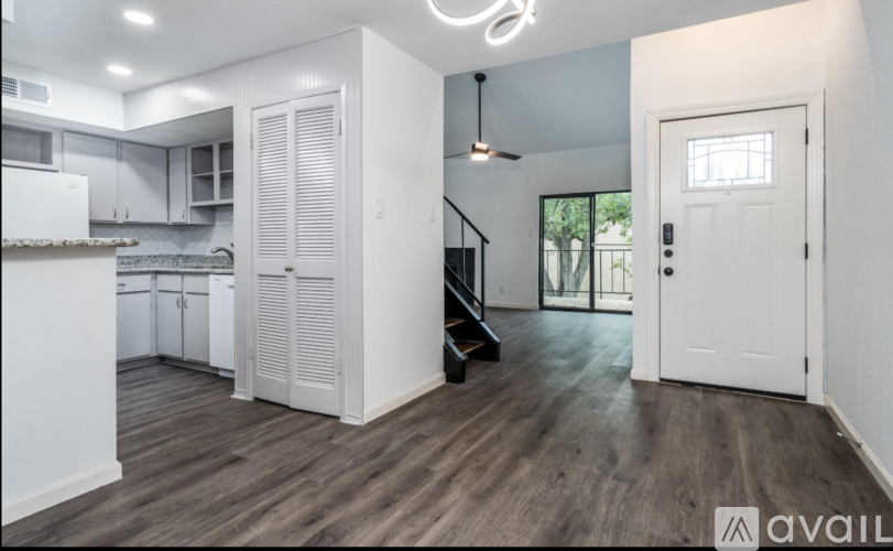 A kitchen with white cabinets and a wooden floor.