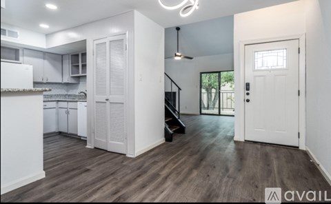 A kitchen with white cabinets and a wooden floor.