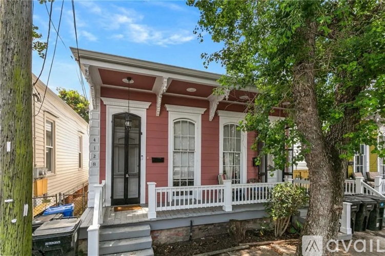 A red and white house with a black door and a white porch.