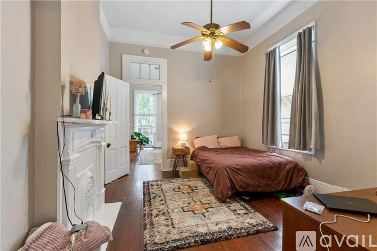 A bedroom with a bed, a ceiling fan, and a rug.