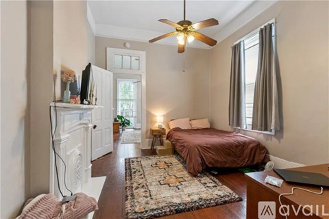 A bedroom with a bed, a ceiling fan, and a rug.