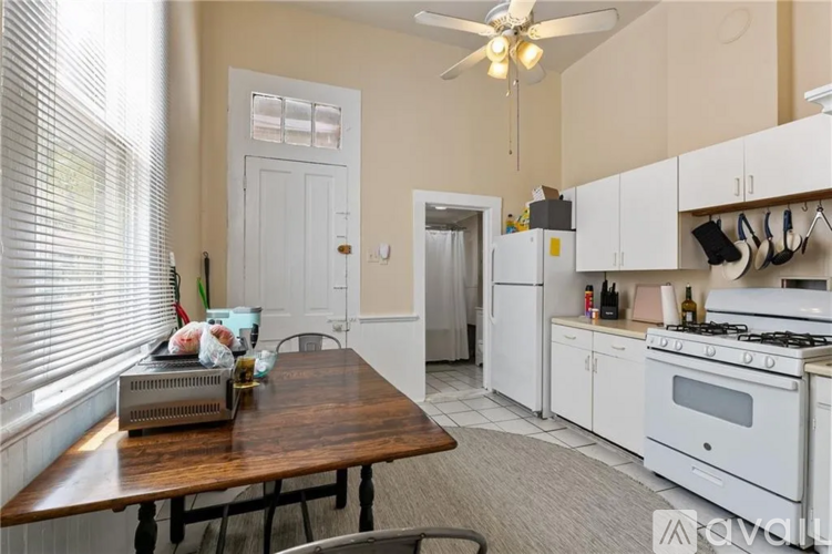 A kitchen with a table and chairs in front of a window.