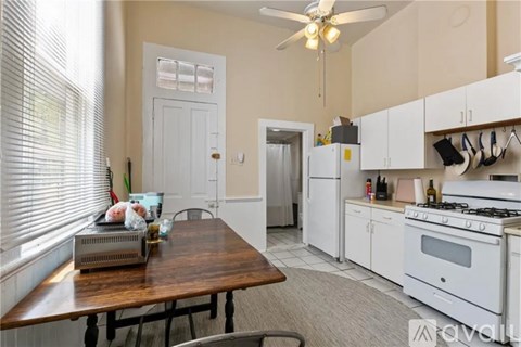 A kitchen with a table and chairs in front of a window.