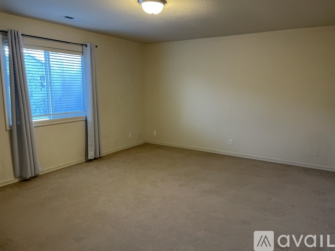 A room with a window and carpeted floor.