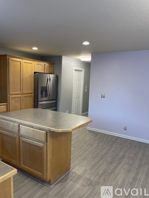 A kitchen with wooden cabinets and a refrigerator.
