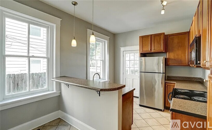 A kitchen with wooden cabinets and a stainless steel refrigerator.
