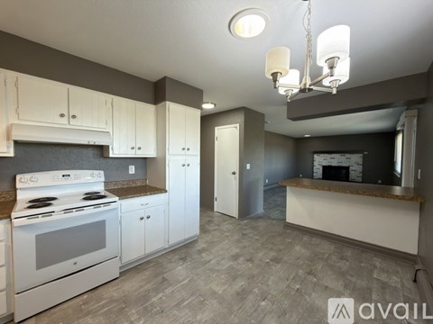 A kitchen with white cabinets and a stove top oven.