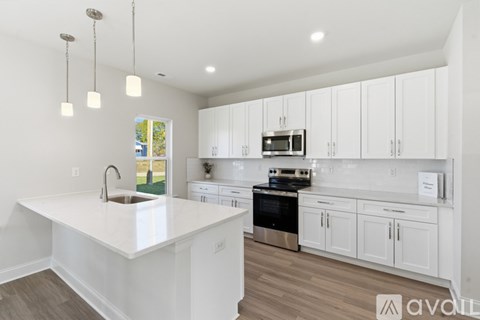 A kitchen with white cabinets and a white island.