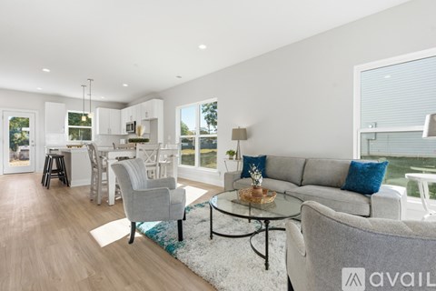A modern living room with a grey sofa and a glass coffee table.