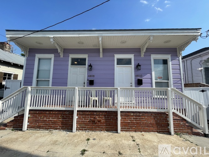 A purple house with a white door and windows.