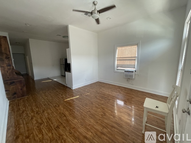 A room with wooden flooring and a ceiling fan.