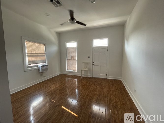 A room with wooden floors and a ceiling fan.