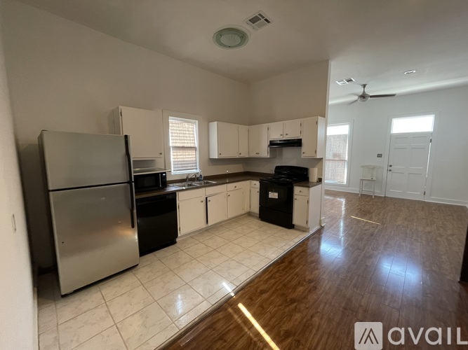 A kitchen with white cabinets and a stainless steel refrigerator.