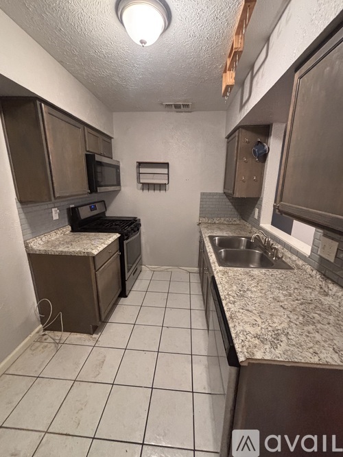 A kitchen with brown cabinets and a granite counter top.
