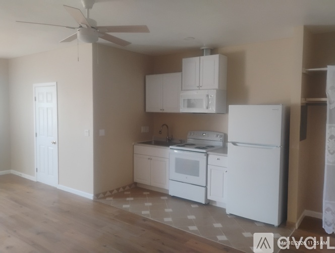 A kitchen with white appliances and cabinets.