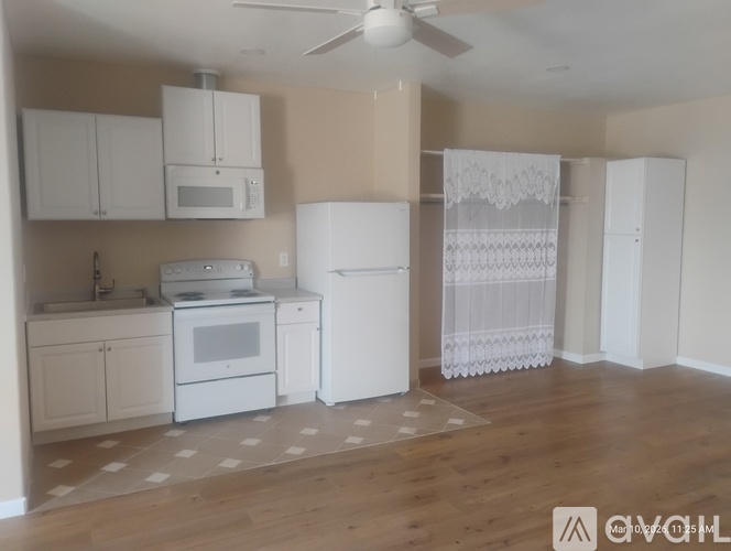 A kitchen with white appliances and cabinets.