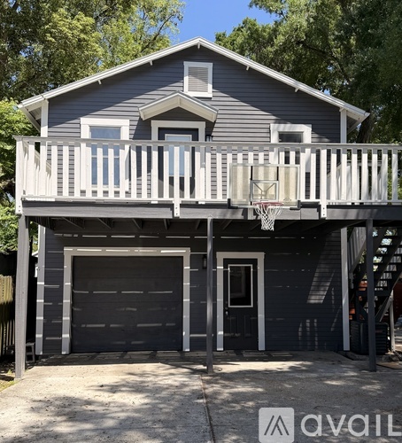 A two-story house with a garage and a basketball hoop on the balcony.