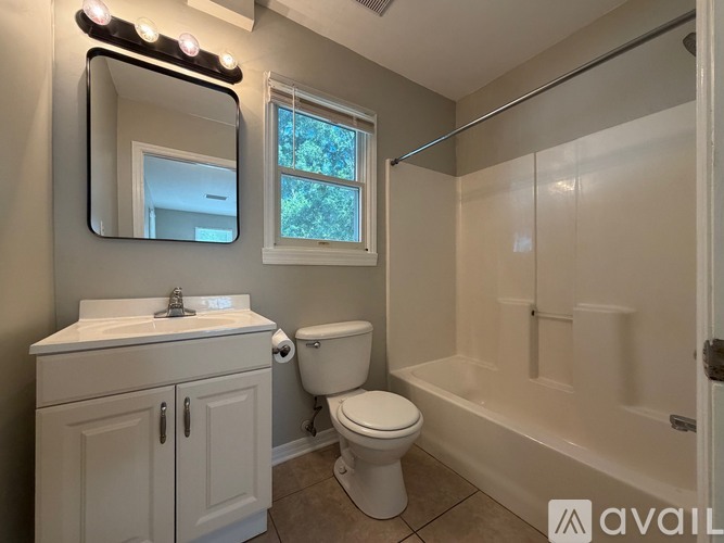 A bathroom with a white toilet, sink, and bathtub.