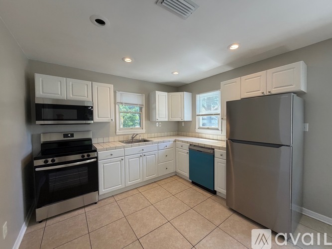 A kitchen with white cabinets and a black stove top oven.