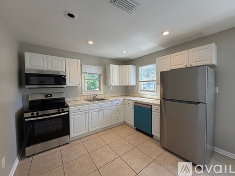 A kitchen with white cabinets and a black stove top oven.