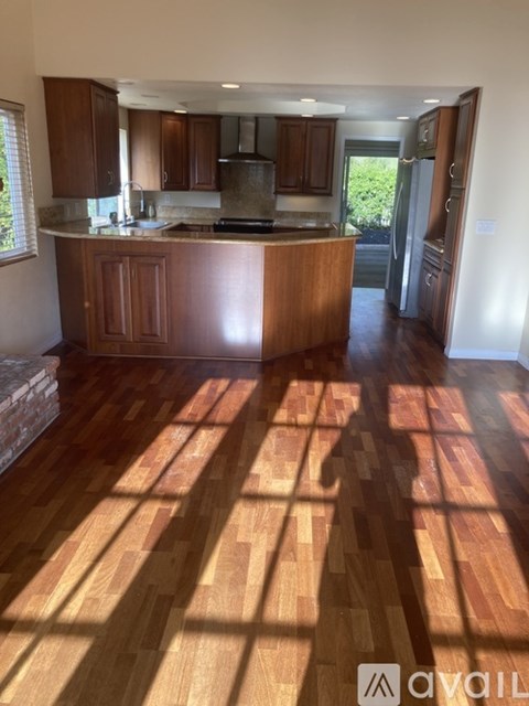 A kitchen with wooden floors and cabinets.