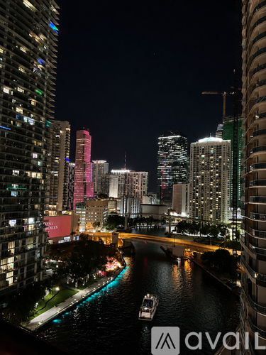 A cityscape at night with a river running through it.