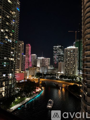 A cityscape at night with a river running through it.