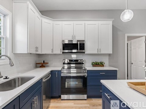 A kitchen with white cabinets and blue countertops.