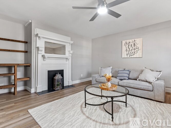 A living room with a fireplace and a painting on the wall.