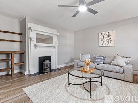 A living room with a fireplace and a painting on the wall.