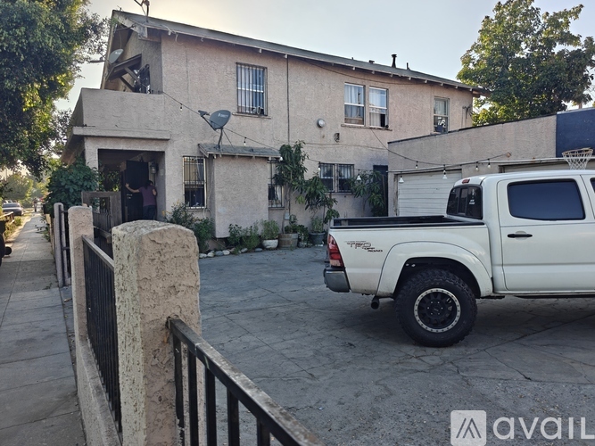 A white pickup truck is parked in front of a house.