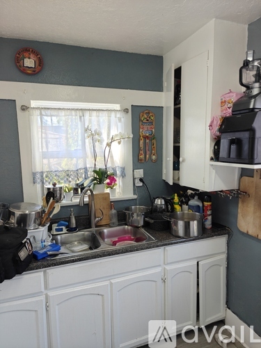 A kitchen with white cabinets and a sink.