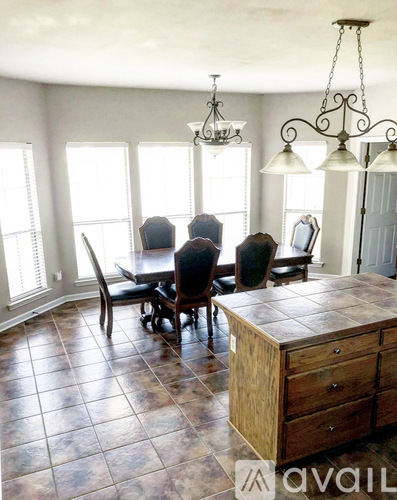 A dining room with a table and chairs.