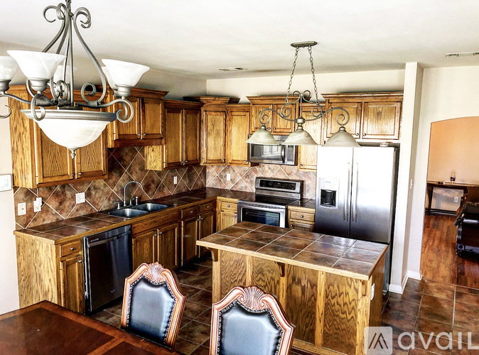 A kitchen with wooden cabinets and a black fridge.