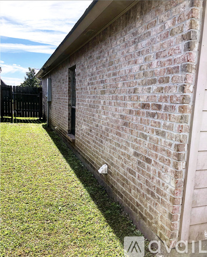 A brick wall with a grassy area in front of it.