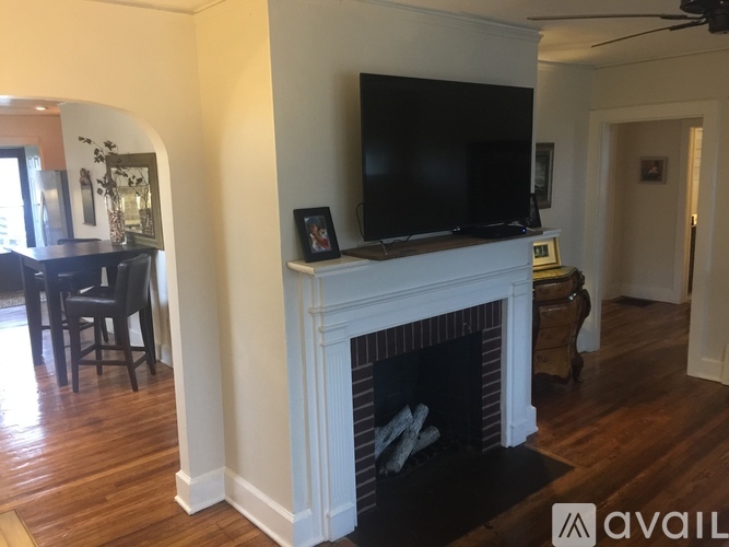 A living room with a fireplace and a television above it.