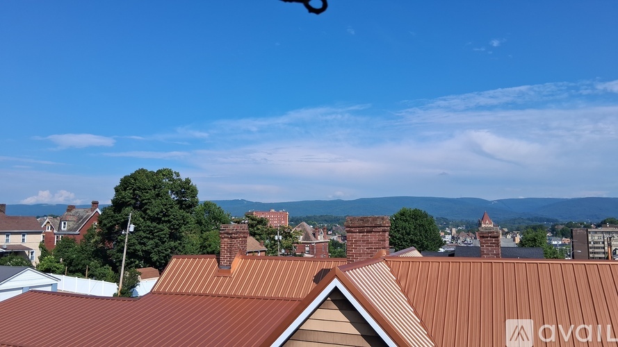 A view from the roof of a house with a brown tiled roof and chimneys.