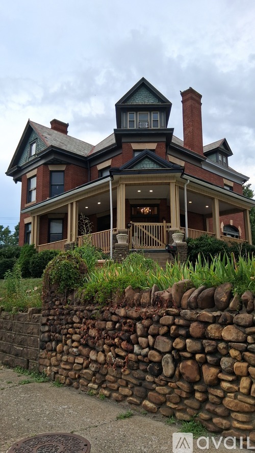 A large house with a stone wall in front.