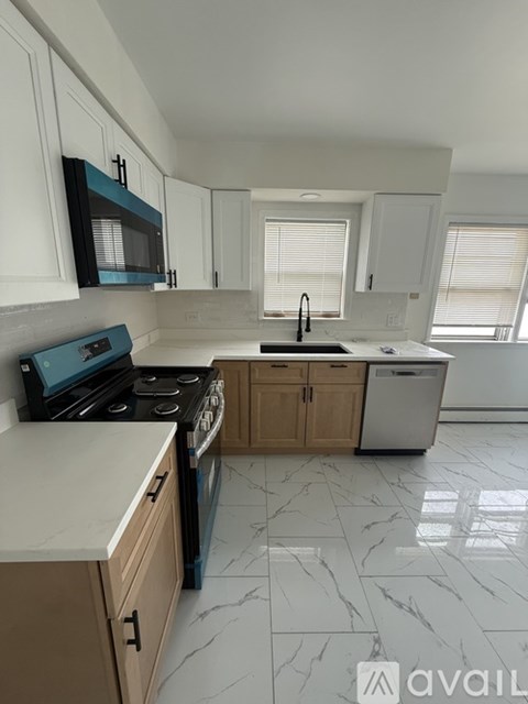 A kitchen with a black stove top oven and white cabinets.