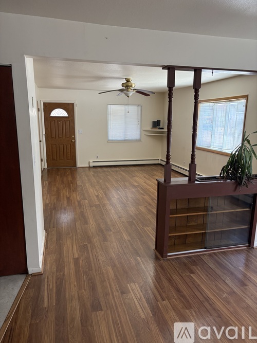 A room with wooden floors and a ceiling fan.