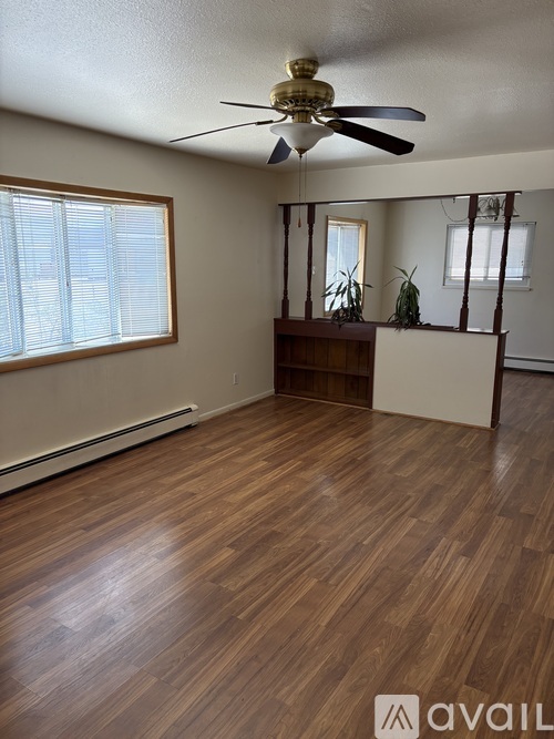 A room with wooden floors and a ceiling fan.